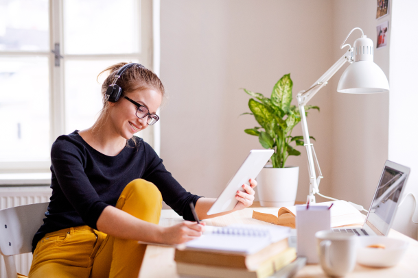 Smiling woman with headphones looking at tablet